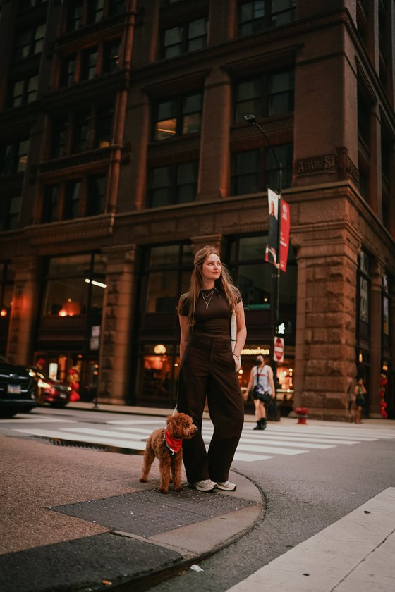 Diana in Chicago standing at a street corner with her dog Pluto in a red bandana